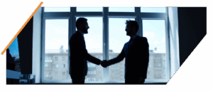 Two professionals shaking hands in front of a window, symbolizing partnership in AI recruitment software by Textkernel and Bullhorn.
